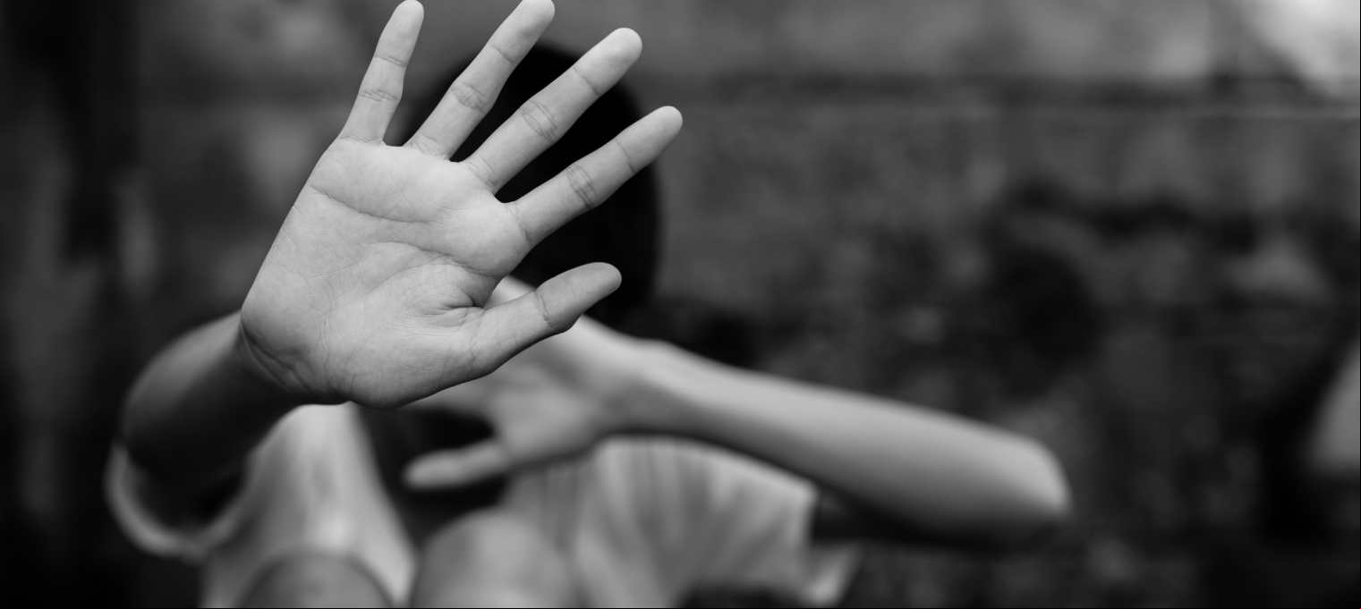 Foto em preto e branco de uma criança triste sem mostrar o rosto, para ilustrar uma vítima de violência sexual